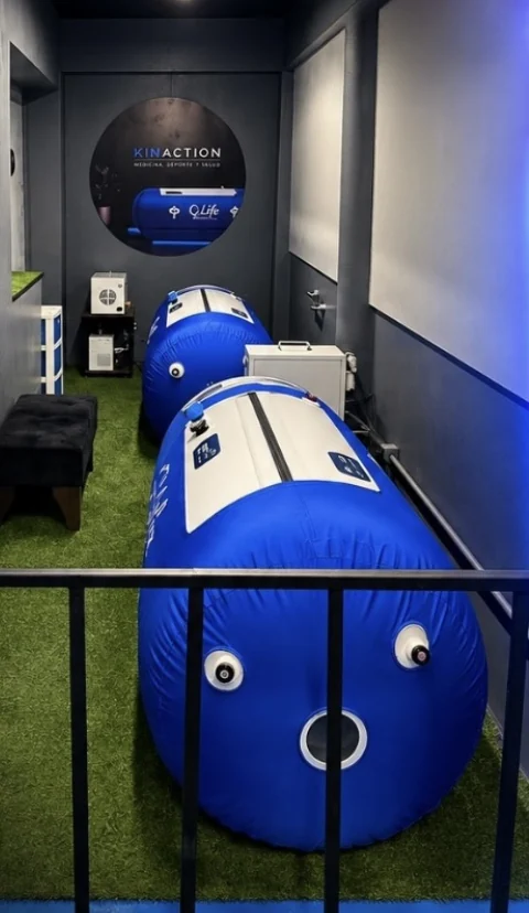 Sala de cámaras hiperbáricas del centro, con dos cámaras azules sobre pasto sintético